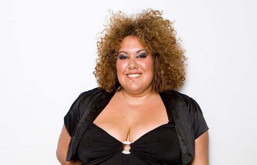 Casey Donovan smiling to camera in black dress
