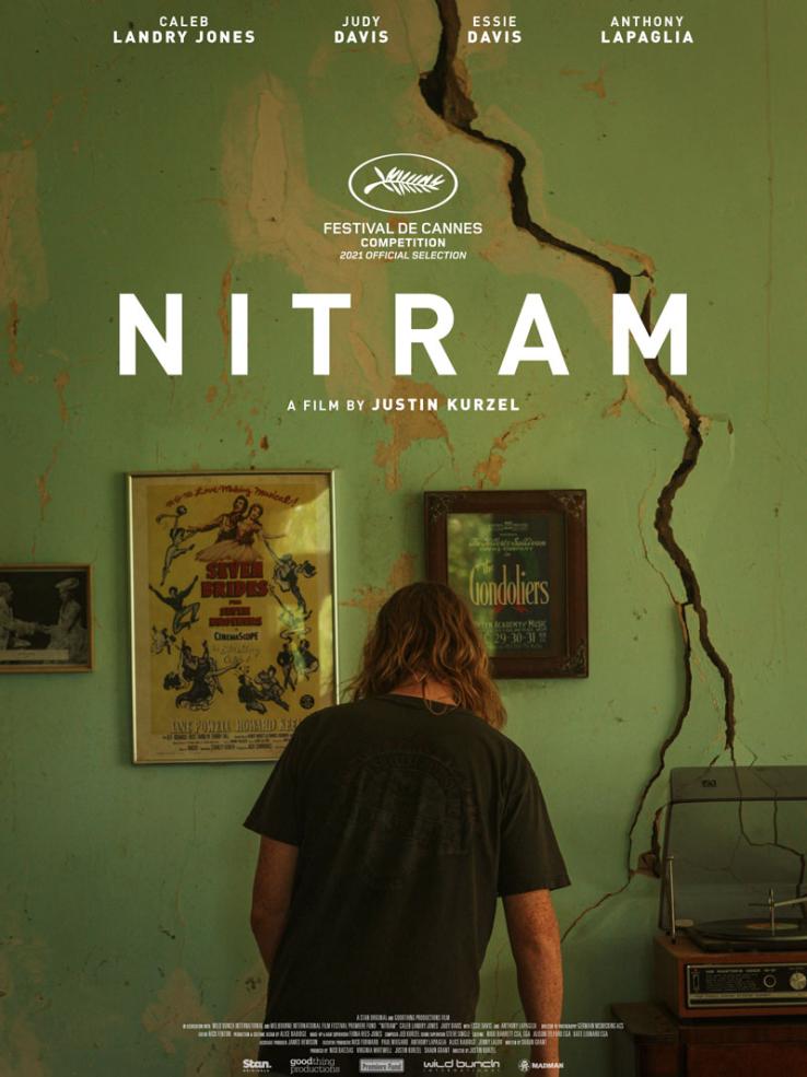film poster for 'Nitram' showing a young man with long blonde hair facing a wall with his back turned to the camera