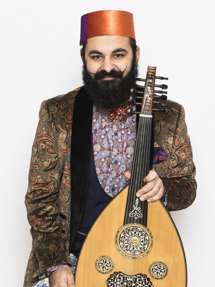Joseph Tawadros wearing a red fez and holding an oud