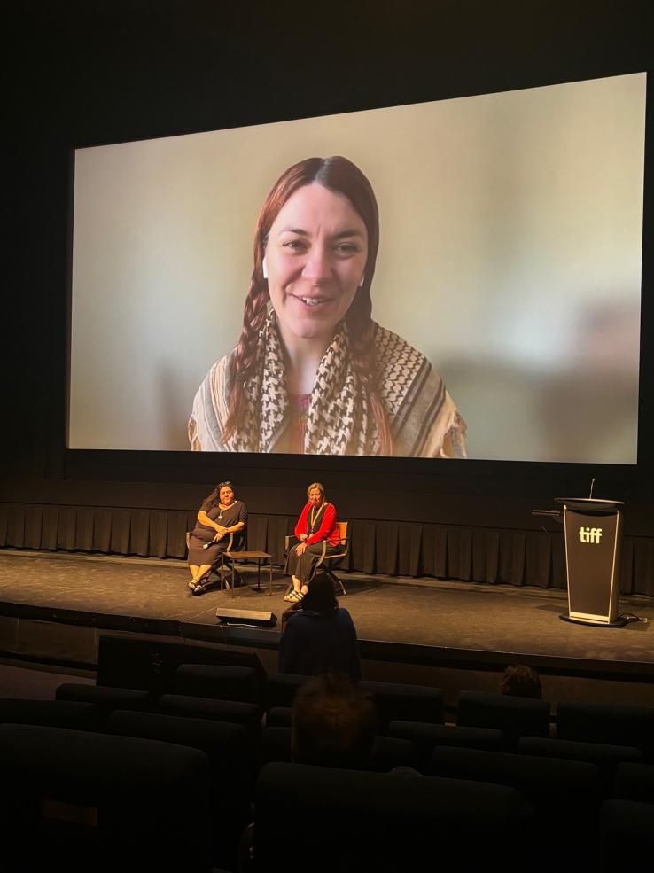 Jazz Money appears on a cinema screen for an online Q&A session. Two people are seated on the stage conducting the Q&A.