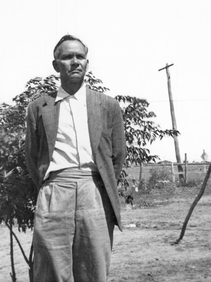 Jimmie Barker standing outside near a tree and a fence