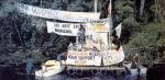 Demonstrators protest with banners on the side of a river