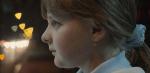 Close up of a young girl's face in profile. She has her hair tied back and is looking straight ahead intently. 