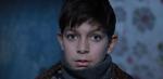 A close up of a young boy looking intently at the camera