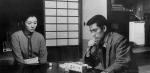 A man and woman sitting at a table looking solemn