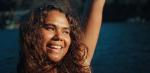 A young woman raising her arm in celebration while attending a music festival