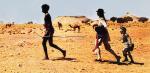 A young Aboriginal man holding a spear leading a teenage girl and young boy, walking in the outback in a scene from Walkabout.