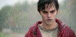 Head and shoulders shot of a young man standing in the rain. He has the look of a zombie - his skin has a grey/bluish tinge and his eyes are red..