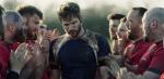 Head and shoulders shot of a group of men wearing rugby jerseys huddled closely together on a field