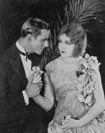 The Cheaters_proposal A dashing young man proposes to a young woman in a sequinned dress
