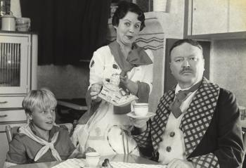 Family of 3 around a dining table.