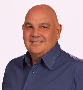 Professor Lyndon Ormond-Parker wearing a blue collared shirt and smiling