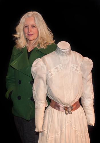 Actor Anne Louise Lambert standing next to a mannequin with the white lace dress costume she wore when filming Picnic at Hanging Rock 40 years earlier