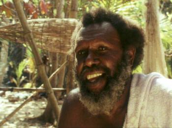 Eddie Mabo at Las - Murray Island Koiki Eddie Mabo smiling. Behind him is a traditional fishing trap used by his people on Mer (Murray Island) in the Torres Strait.