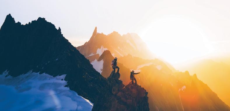 Two climbers standing on peak of mountain 