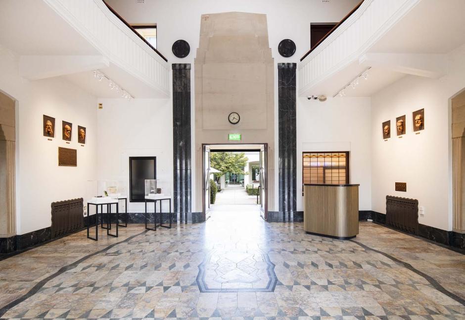 The Art Deco foyer of the National Film and Sound Archive with display cases and a small desk on either side of the open doors leading to the courtyard