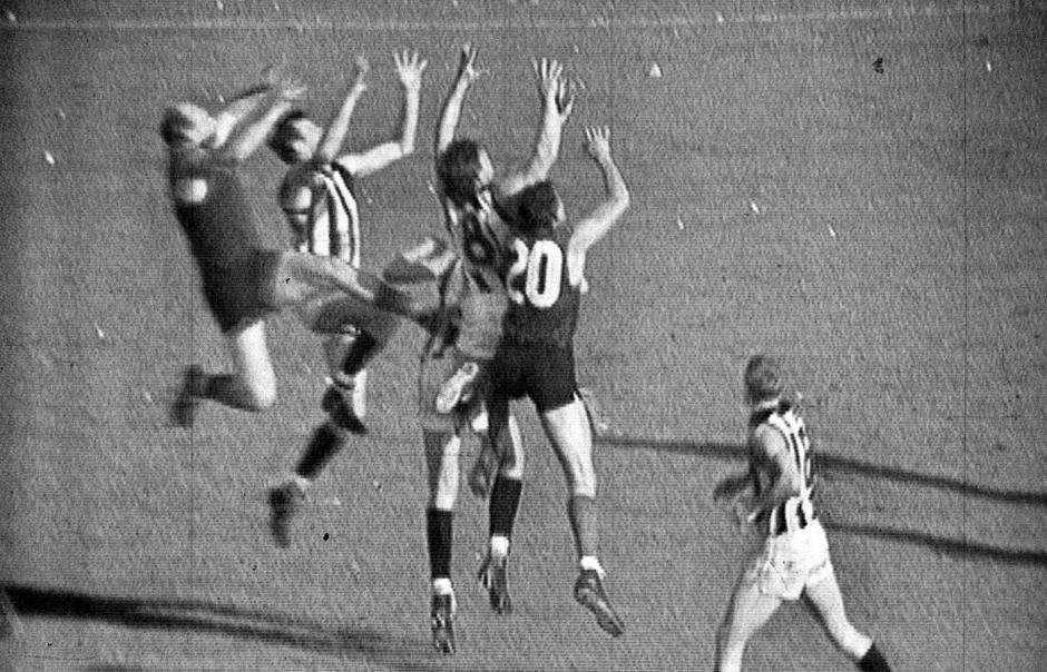 Australian Rules Football players jumping for the ball in the 1964 grand final match.