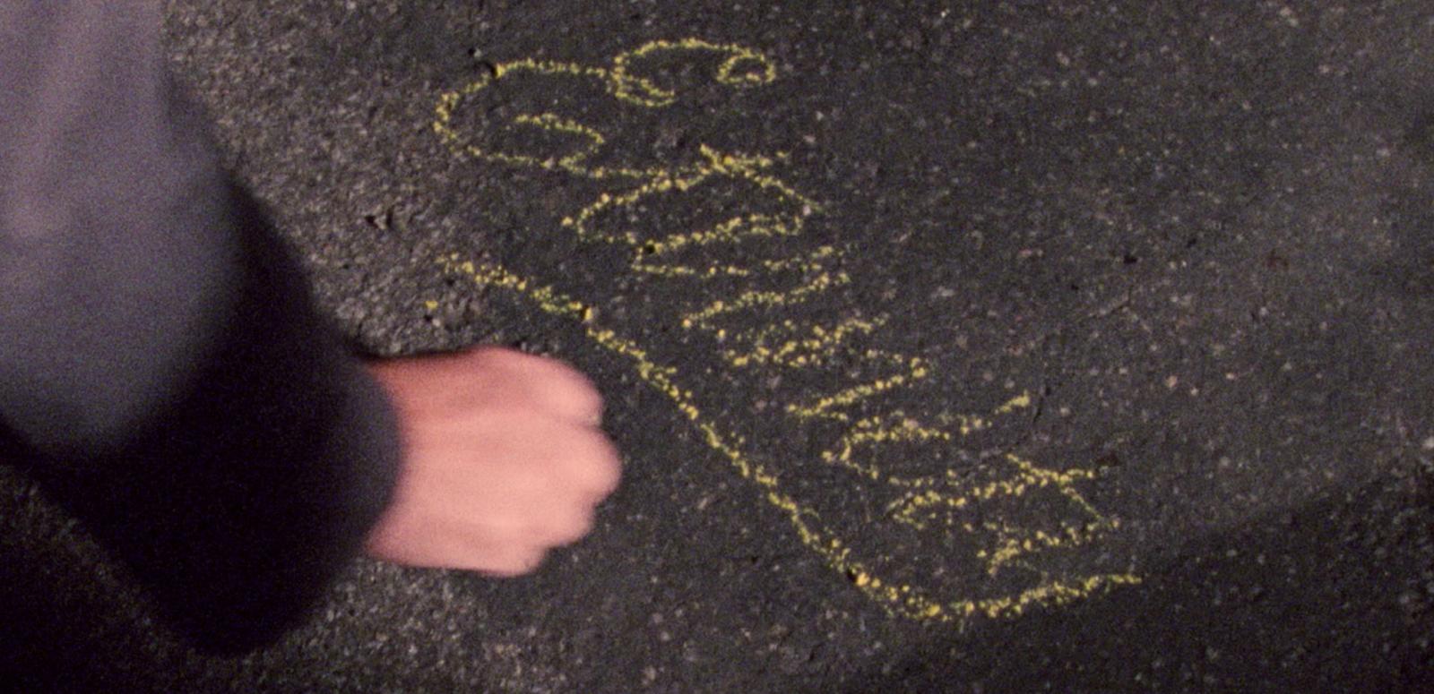 Image of a hand writing 'Eternity' in chalk on the sidewalk