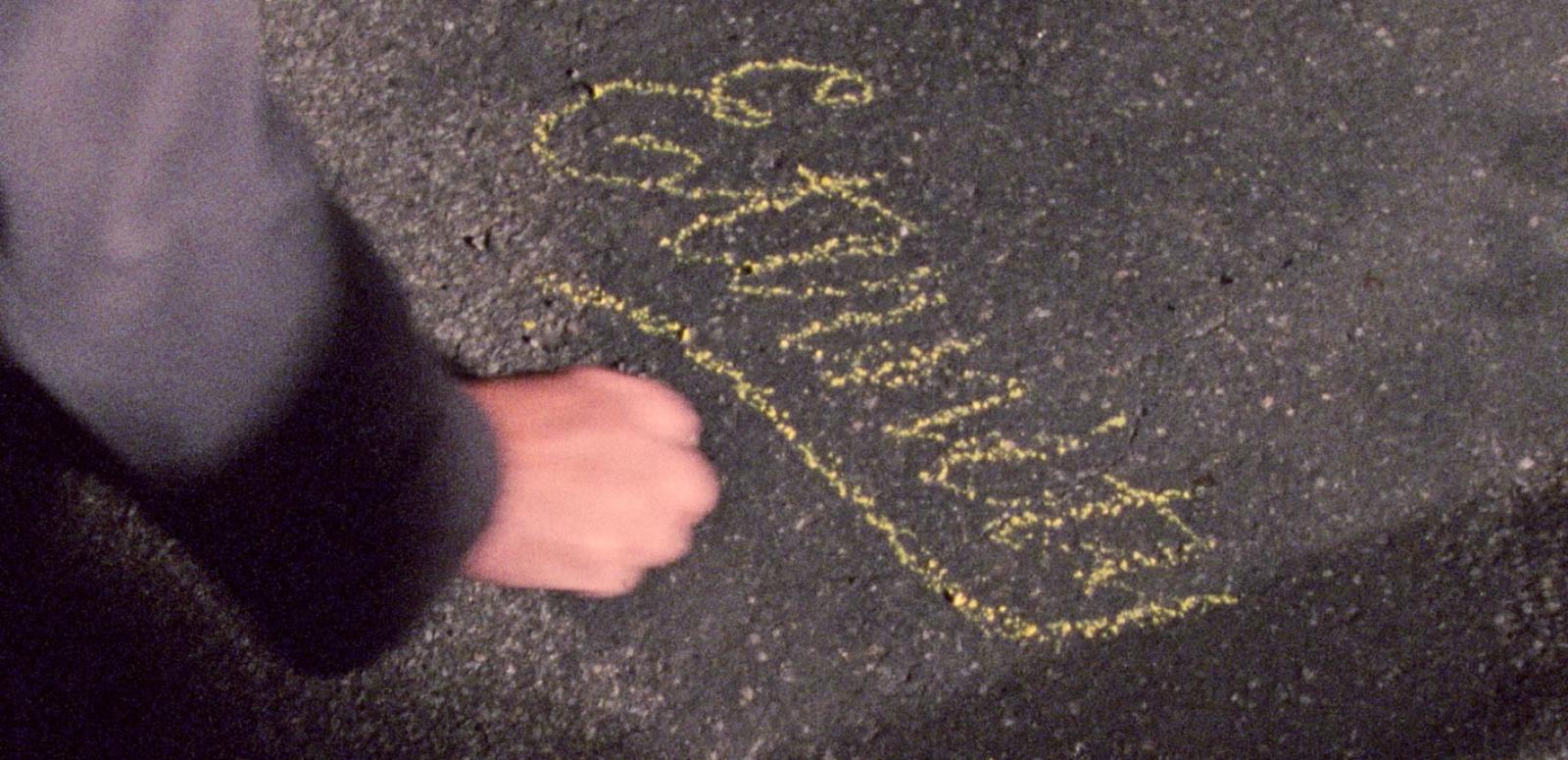 Image of a hand writing 'Eternity' in chalk on the sidewalk