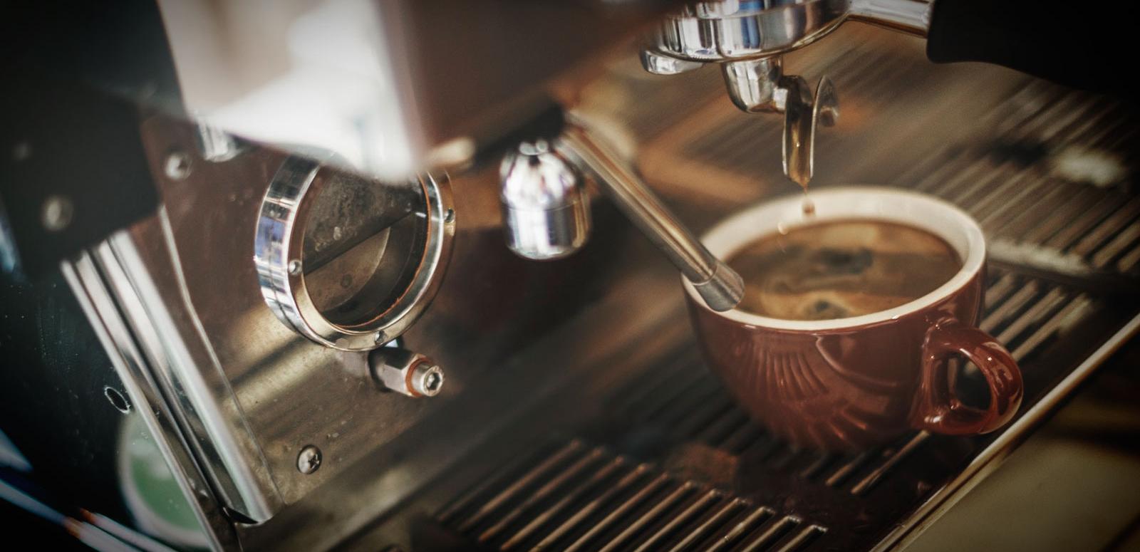 Close up of a coffee machine and a cup being filled with coffee.