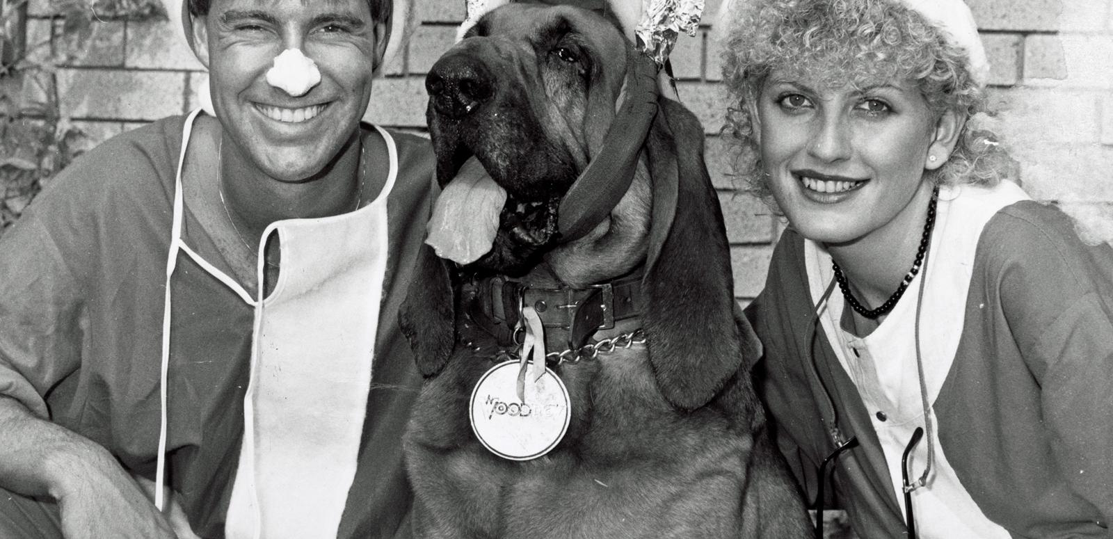 Brett Clements, Woodrow the Bloodhound and Edith Bliss. Brett and Edith are dressed in Santa suits and Woodrow is wearing reindeer antlers