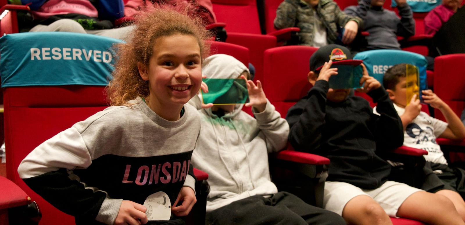 Smiling girl in a theatre with other cildren Smiling girl in a theatre with other cildren