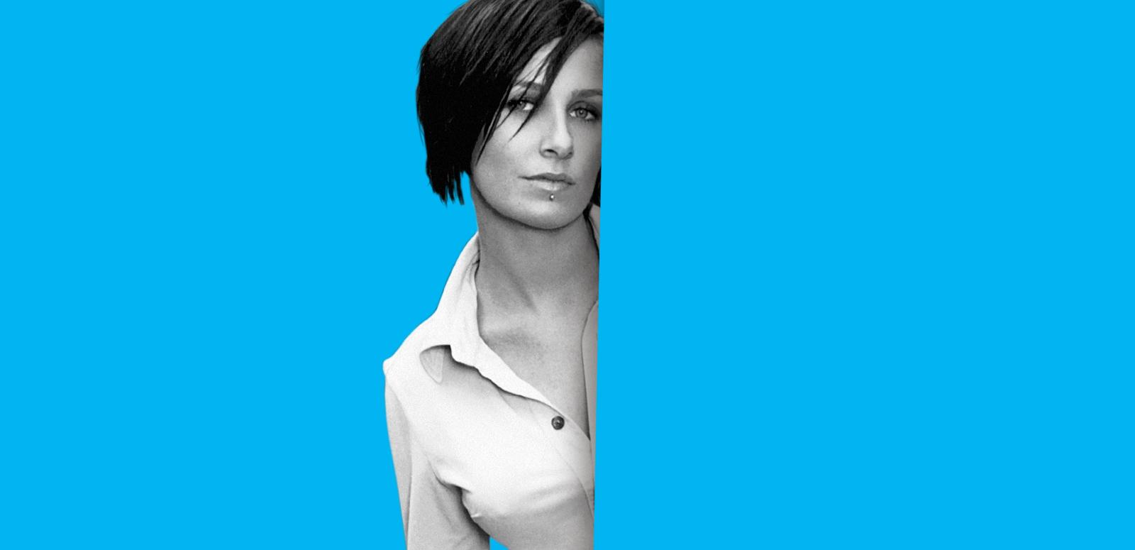 Singer Kasey Chambers shot from the chest up looking directly at camera, one side of her body is partially obscured