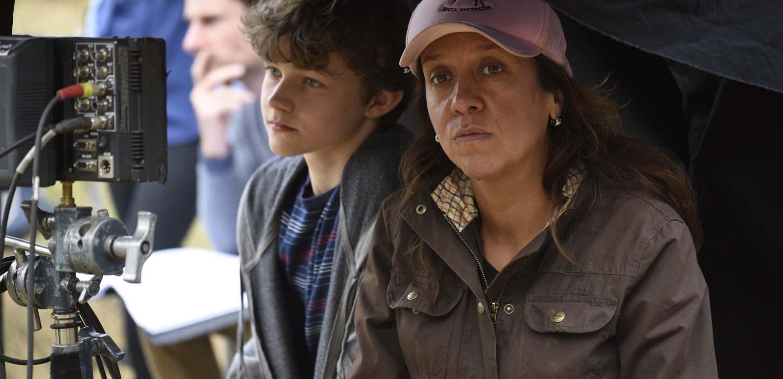 Director Rachel Perkins on a film set with child actor Levi Miller. Levi is looking through a monitor while Rachel looks at the camera