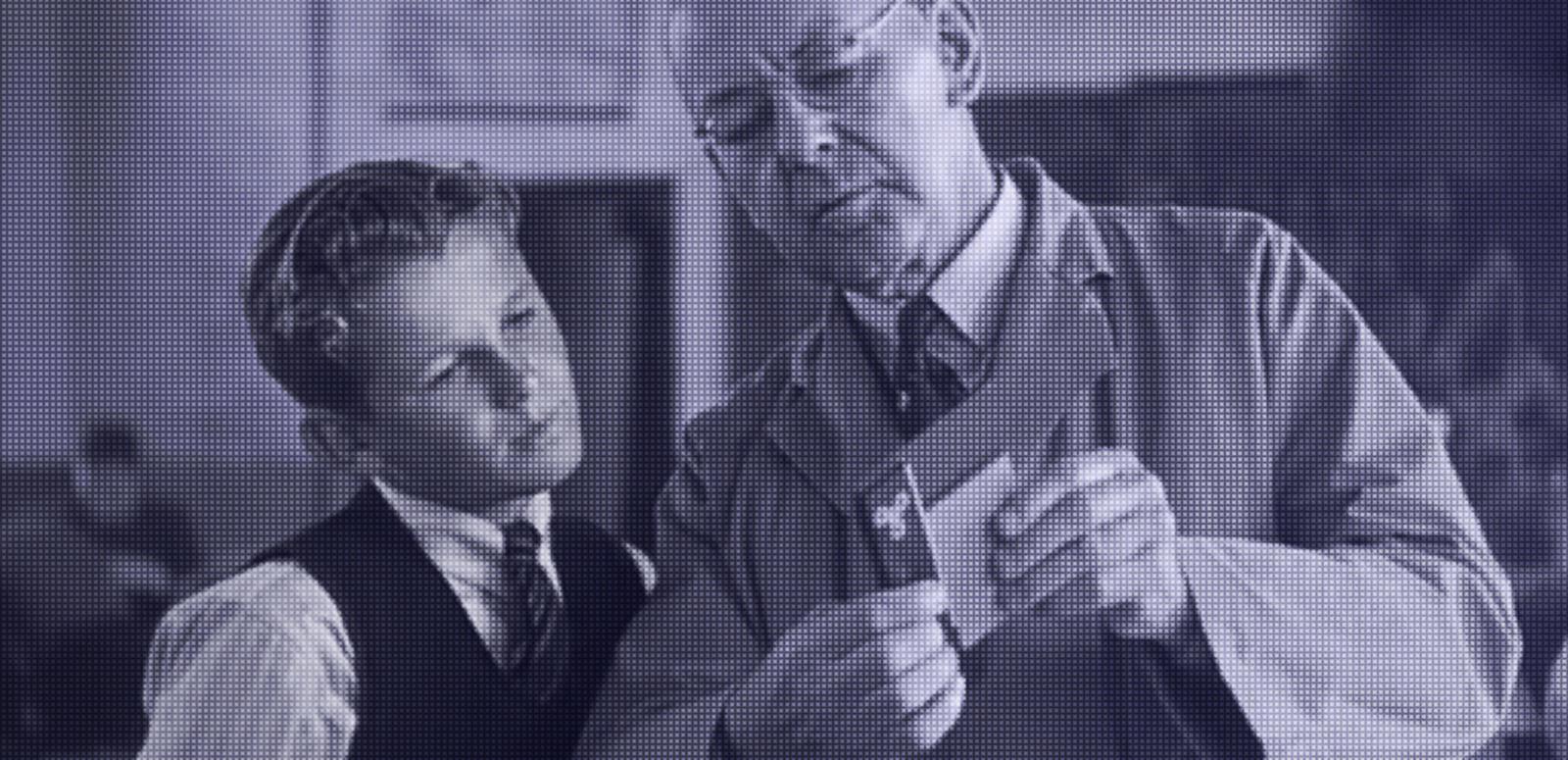 A teenaged boy and teacher looking at a piece of paper
