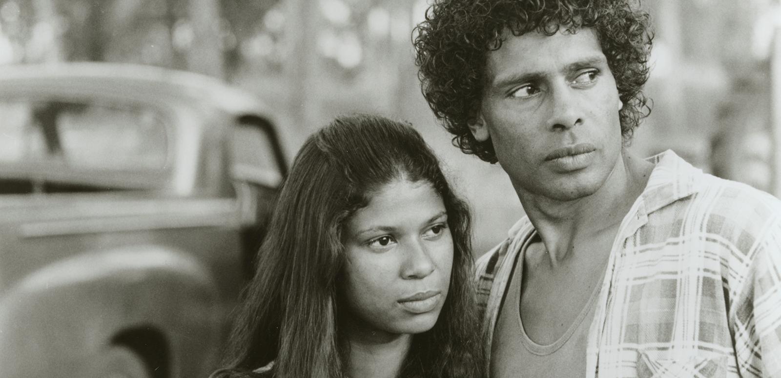 A young Aboriginal woman and man looking at something off camera, with serious-looking expressions.