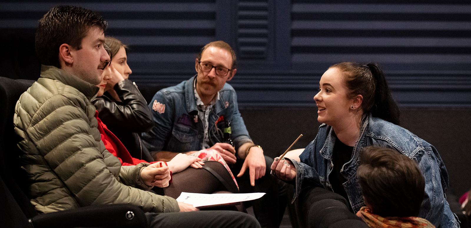 A group of four people sitting in a huddle.