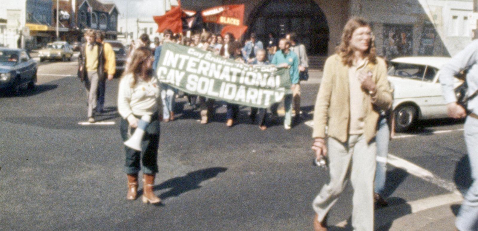 People at a protest march holding banners and loudspeakers