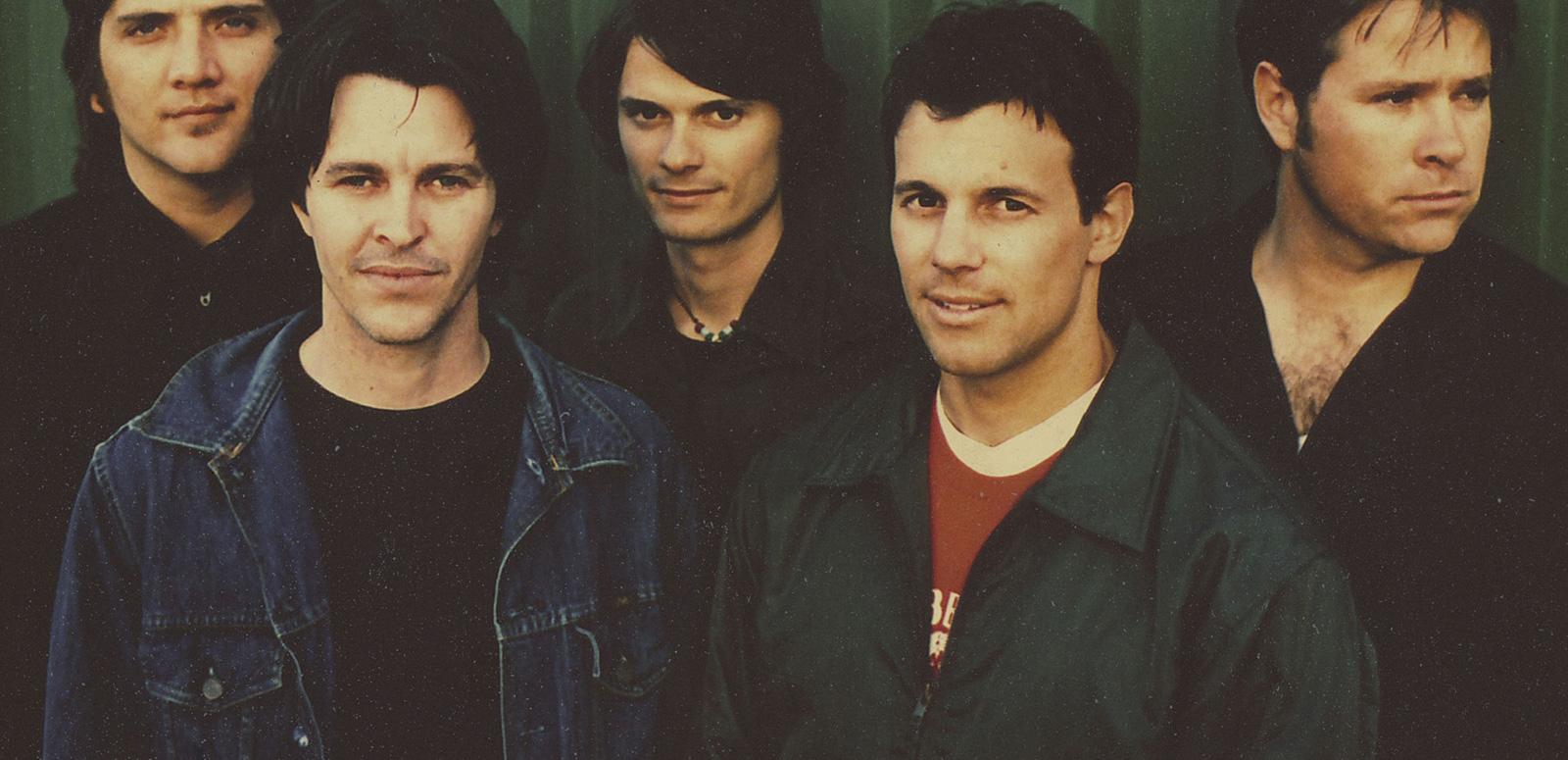 Head and shoulders shot of the five members of the band Powderfinger standing side by side looking at camera.