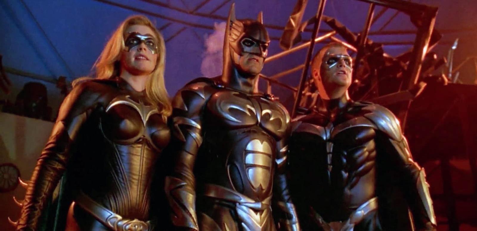 A woman and two men dressed as super heroes in a scene from the film Batman & Robin.