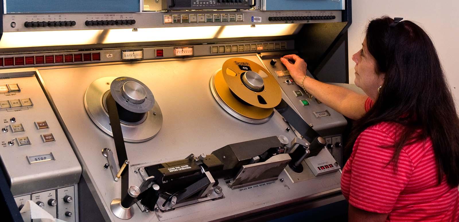 A female staff member works at a tape editing machine at the NFSA