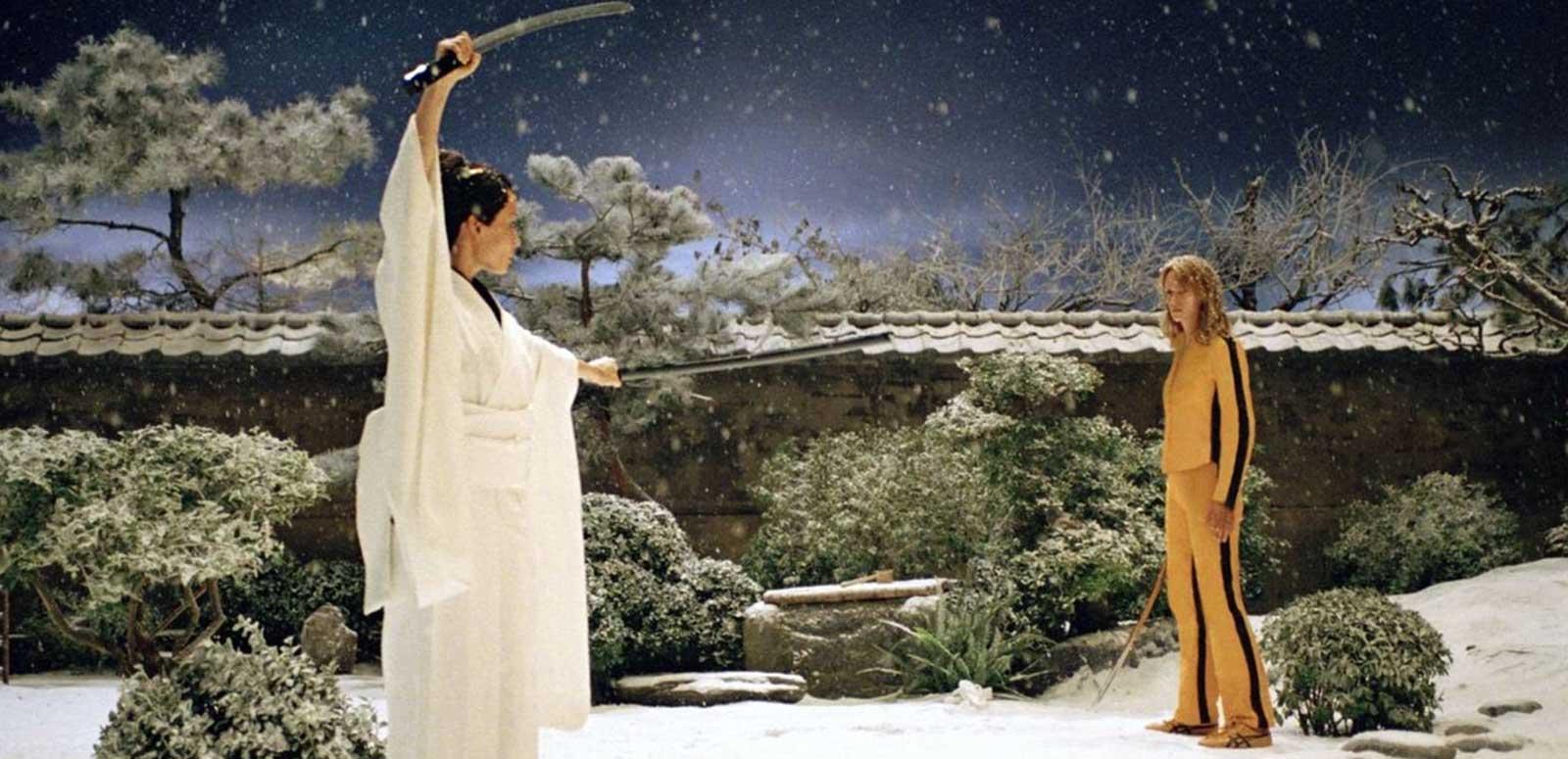 Two women, one dressed in white and the other in yellow, facing off against each other in a samurai sword battle, in a scene from Kill Bill: Volume 1
