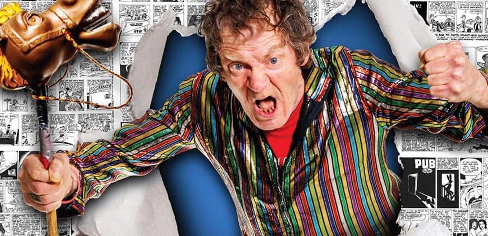 An angry man bursting through a poster making fists with his hands. In one hand he is gripping a toy horse.
