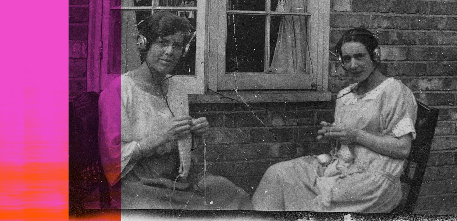 Two women sitting outside knitting and listening to the radio through headphones, c1920s