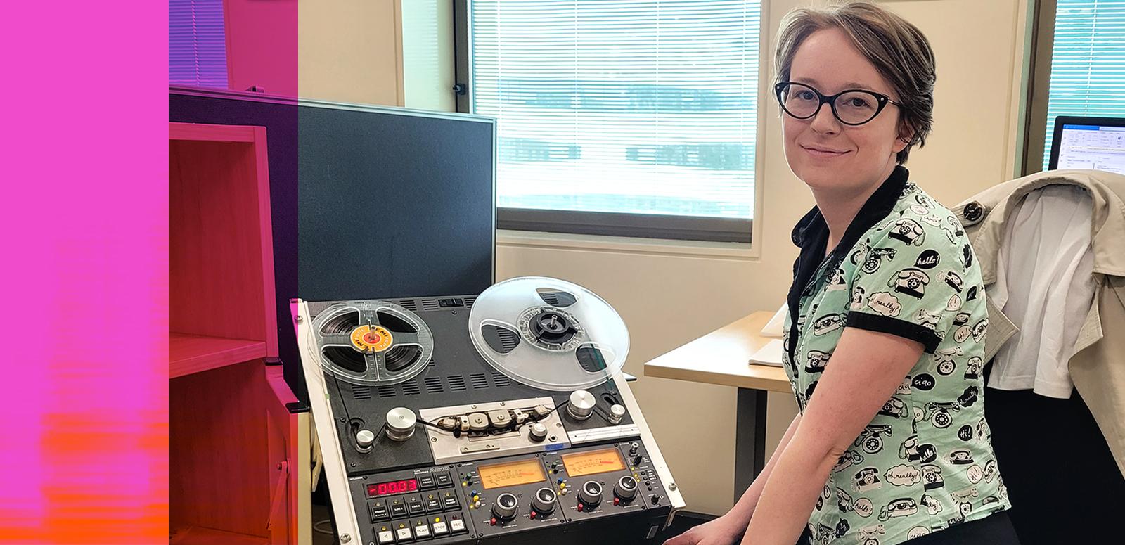 NFSA curator Amy Butterfield, seated and looking up at the camera. She is sitting next to some audio equipment