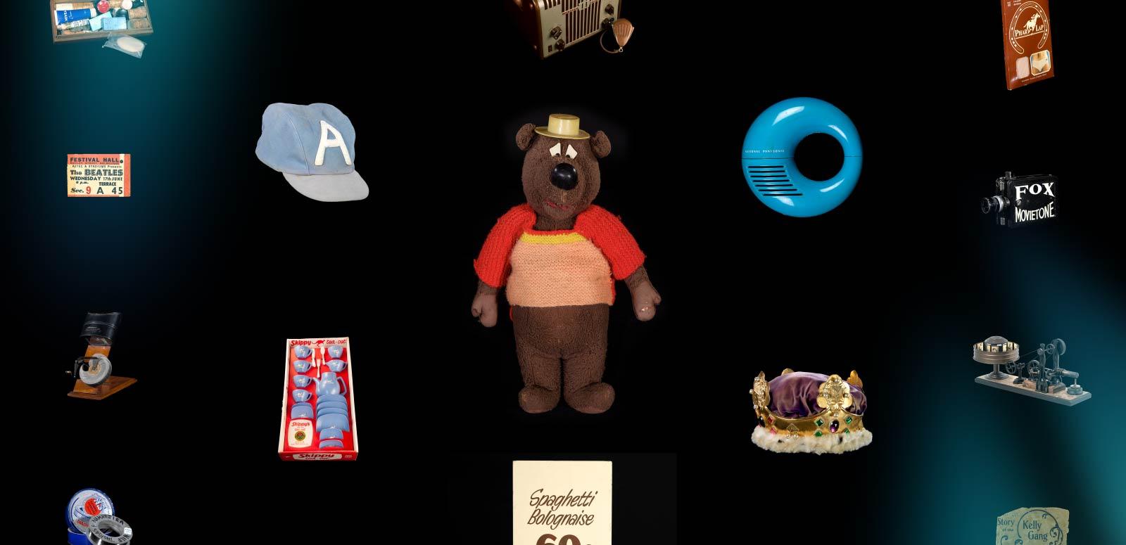 A range of ephemera sitting against a black backround, including a cap, toy bear, retro radio, child's tea set and other items.
