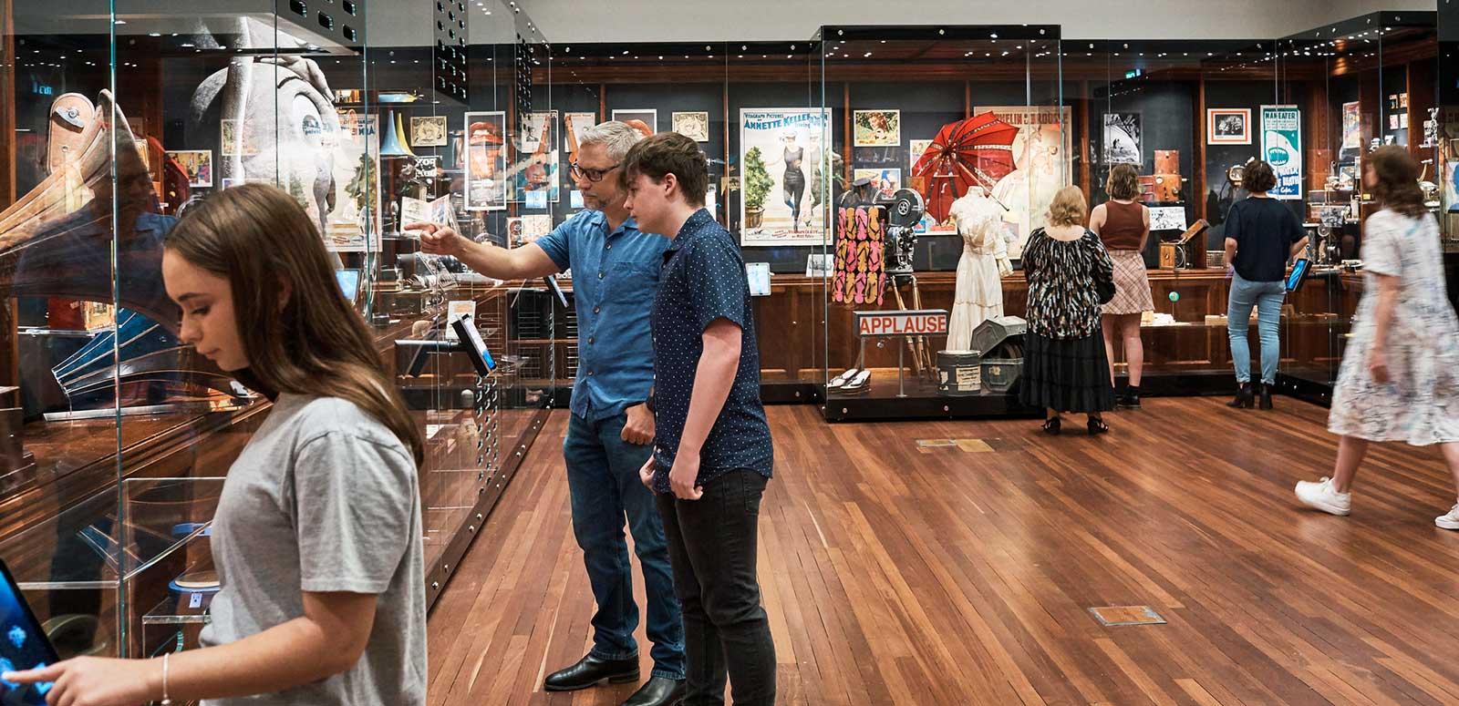People looking at items in an exhibition space.