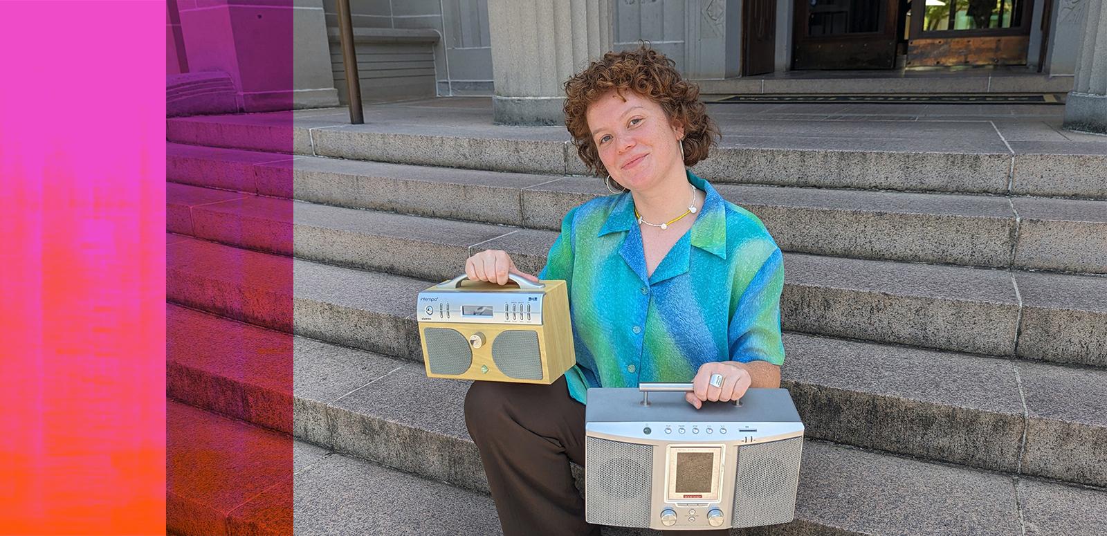 A woman sits on concrete steps holding two portable radios, one on each knee