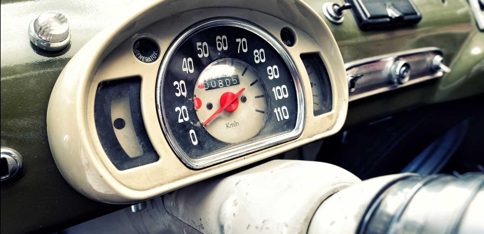 A dashboard of a vintage car showing the speedometer.