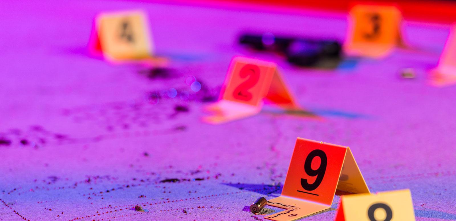 Evidence markers on the ground under neon lighting