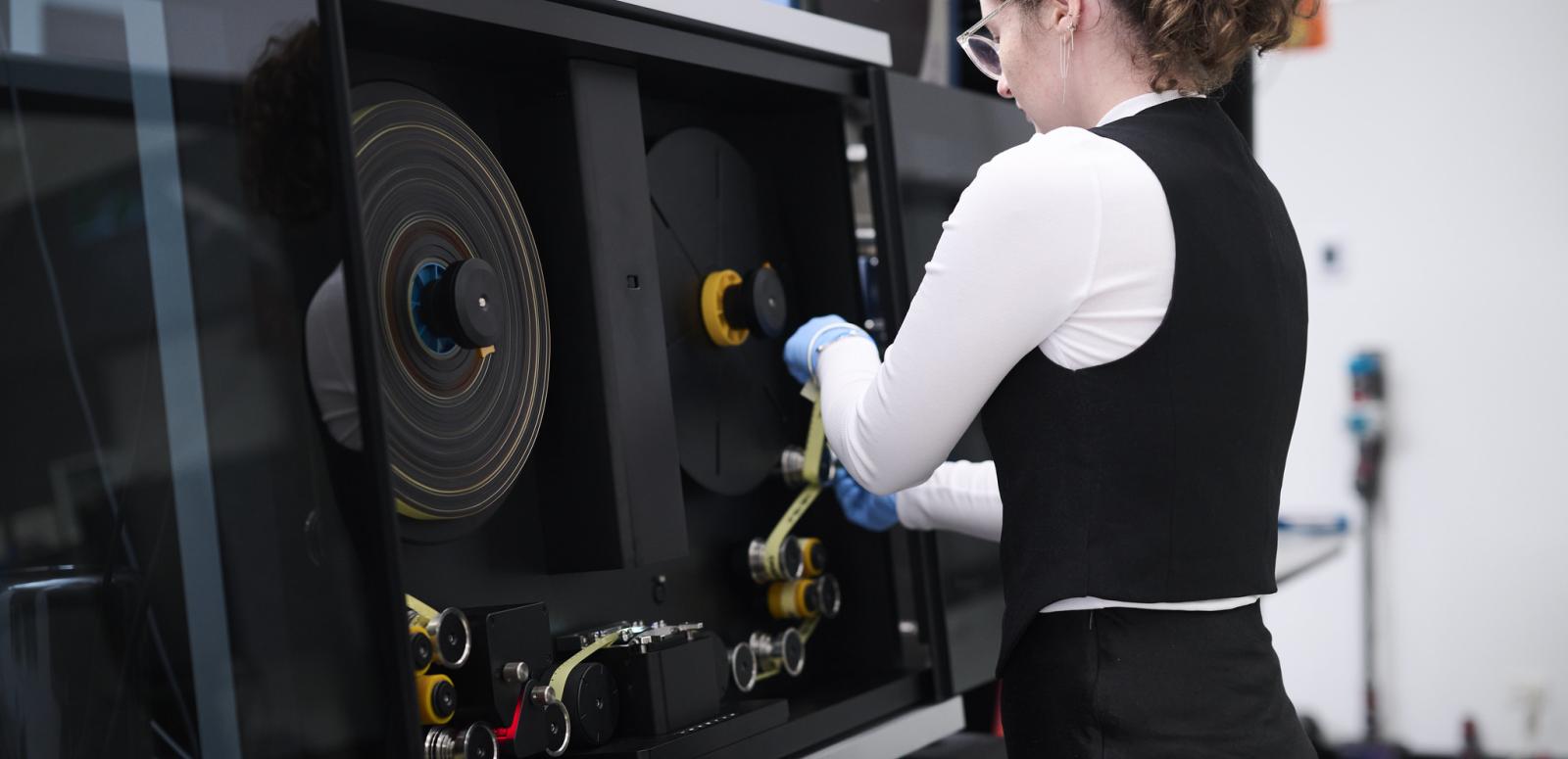 Woman working at a film digitisation machine