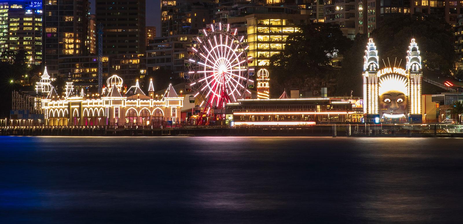 Luna Park in Sydney lit up at night, pictured from across Sydney Harbour
