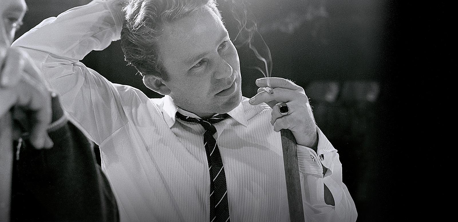 Johnny O'Keefe smoking a cigarette and holding a broom in the TV studio Johnny O'Keefe smoking a cigarette and holding a broom in the TV studio