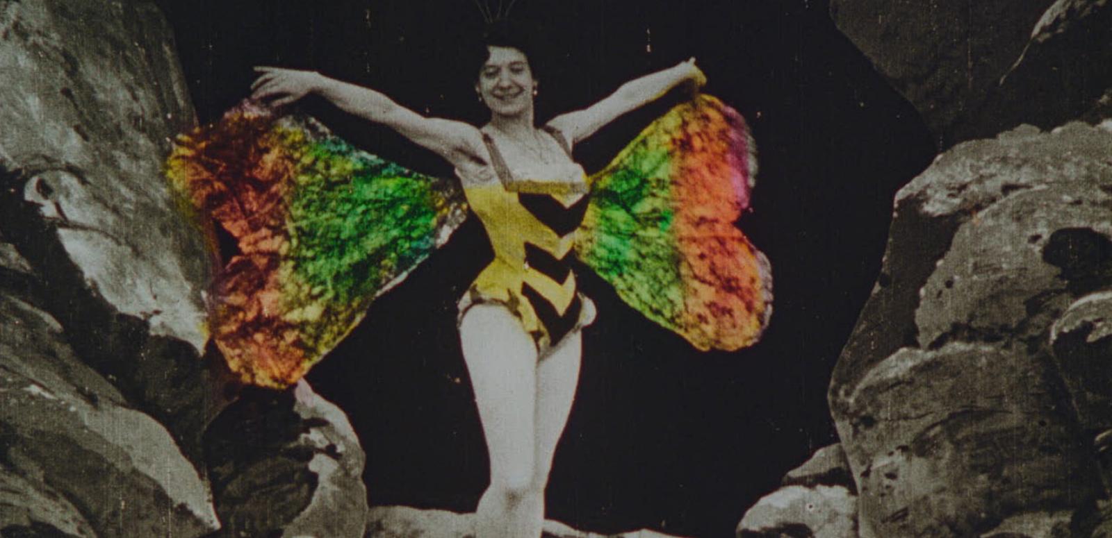 Handcoloured image of woman wearing a yellow dancer's costume and colourful butterfly wings Handcoloured image of woman wearing a yellow dancer's costume and colourful butterfly wings