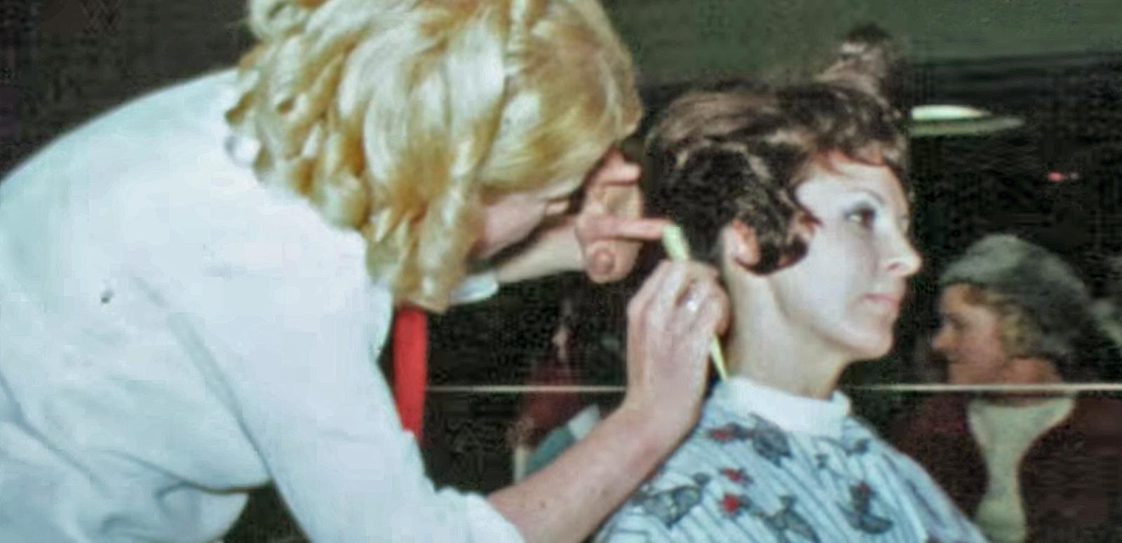 Woman cutting another woman's hair at hair-dressing competition, circa 1960.