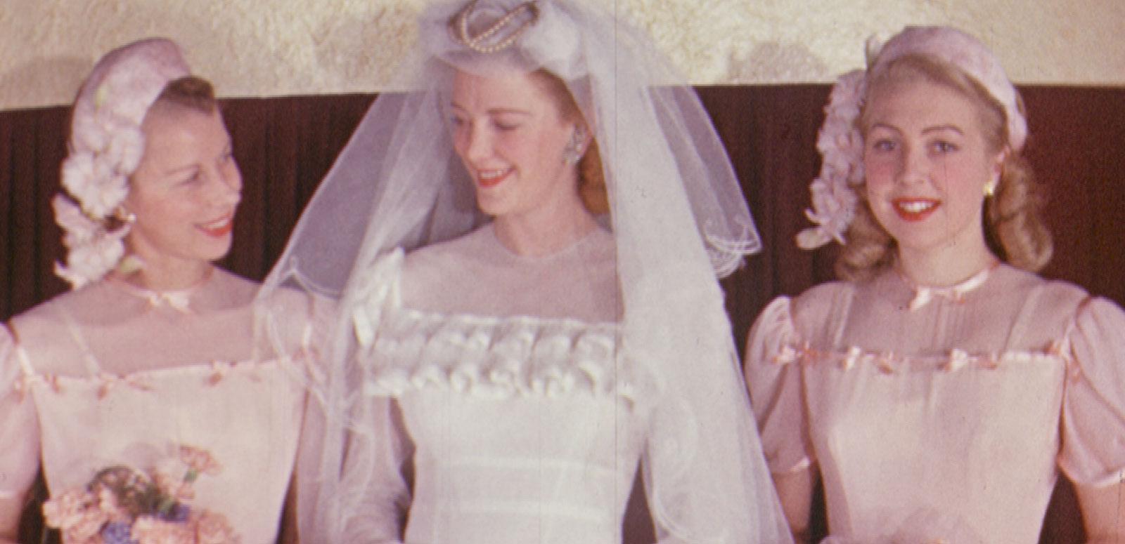 Mark Foy's Bridal Fashion Three women pose for the camera. One wears a white wedding gown. The other two are bridesmaids in pink.